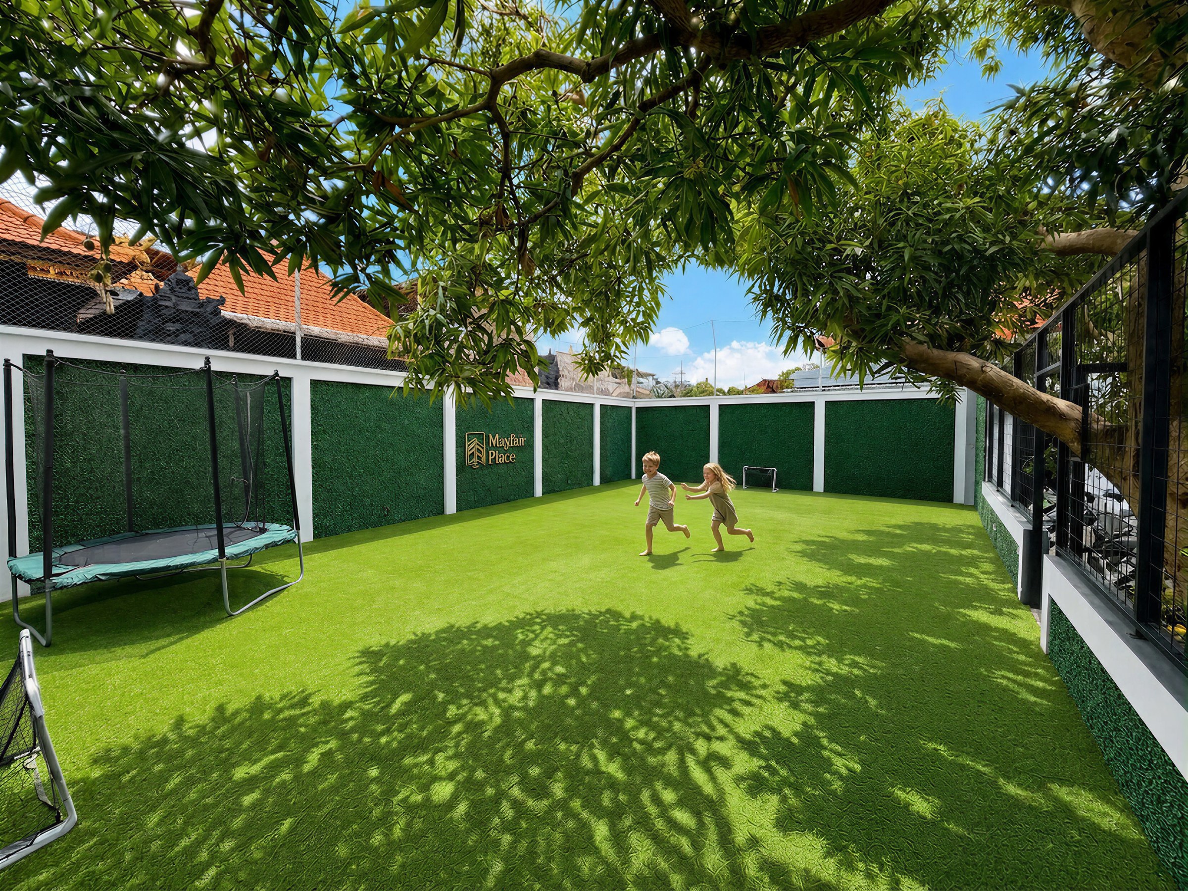 The shared, gated green at Mayfair Place, framed by Balinese temple rooftops